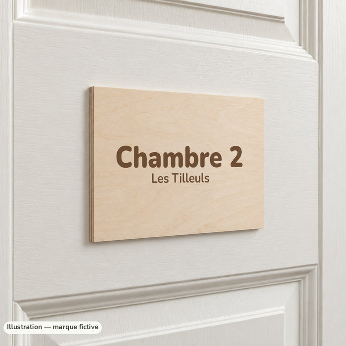 Plaque de porte en bois de tilleul gravée « Chambre 2 » sur une porte blanche à moulures (exemple)